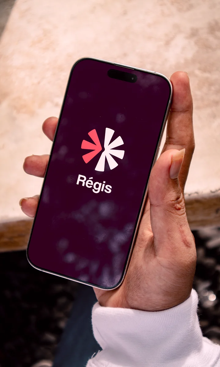 Écran de lancement de l’application Régis sur un téléphone tenu en main.